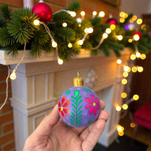 Hand-painted wooden Christmas ornament with floral pattern, close-up detail