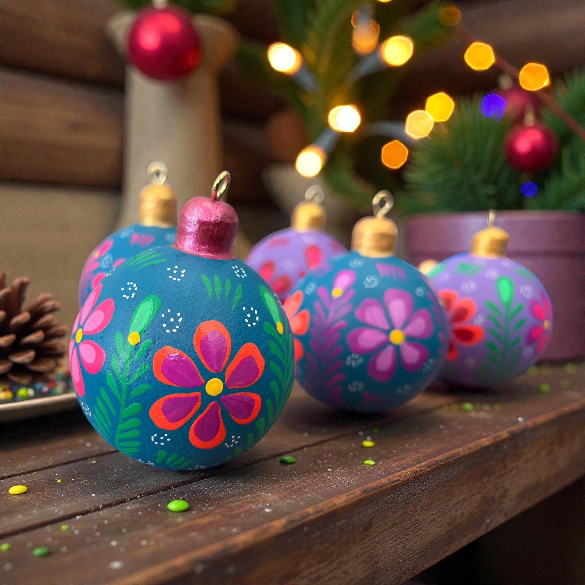 Hand-painted wooden Christmas ornaments with multicolor flowers displayed together