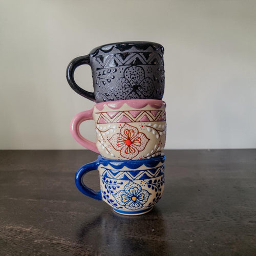 Black espresso cup size comparison in hand