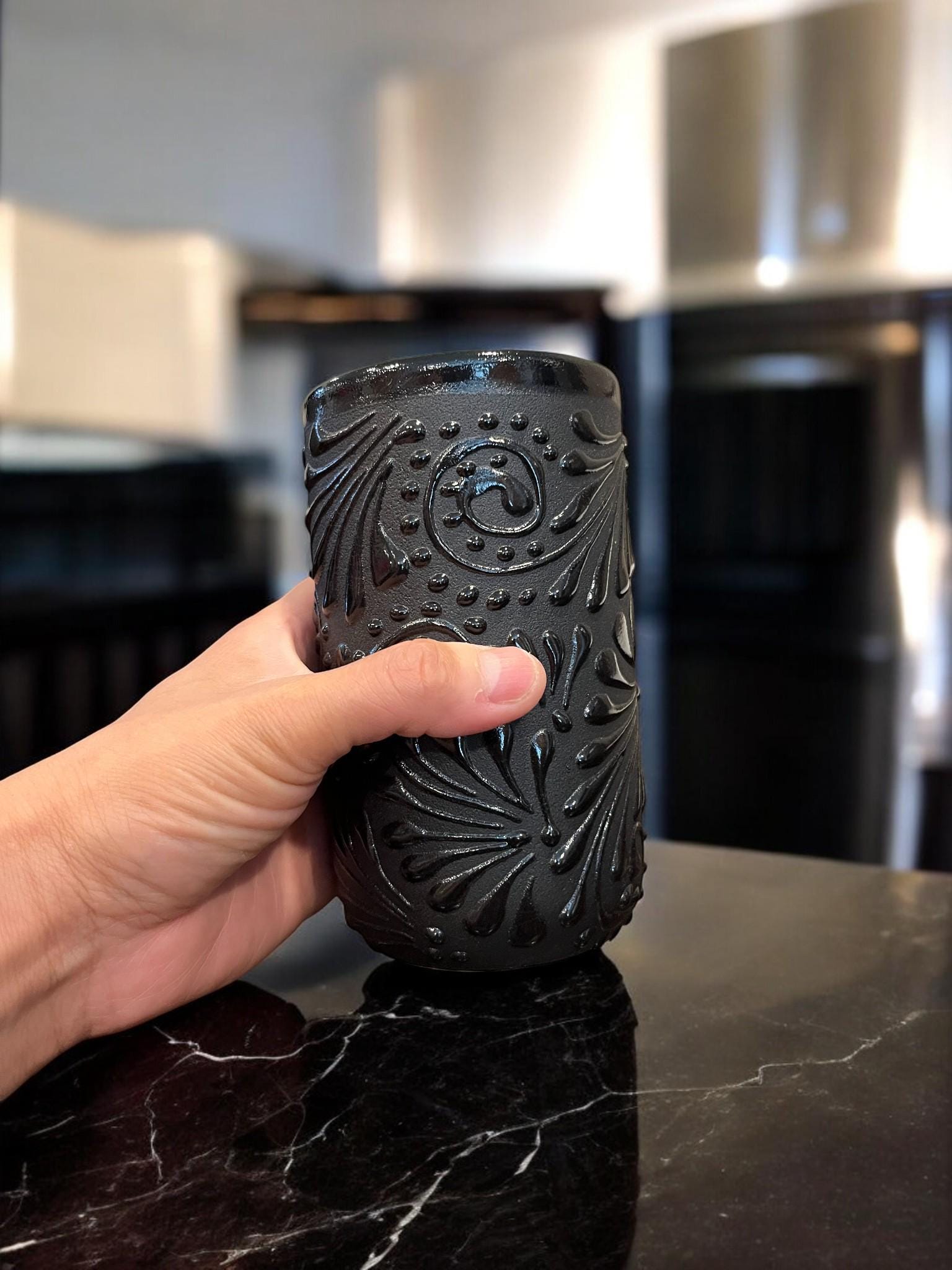 Close-up of a black Talavera cup's intricate raised pattern