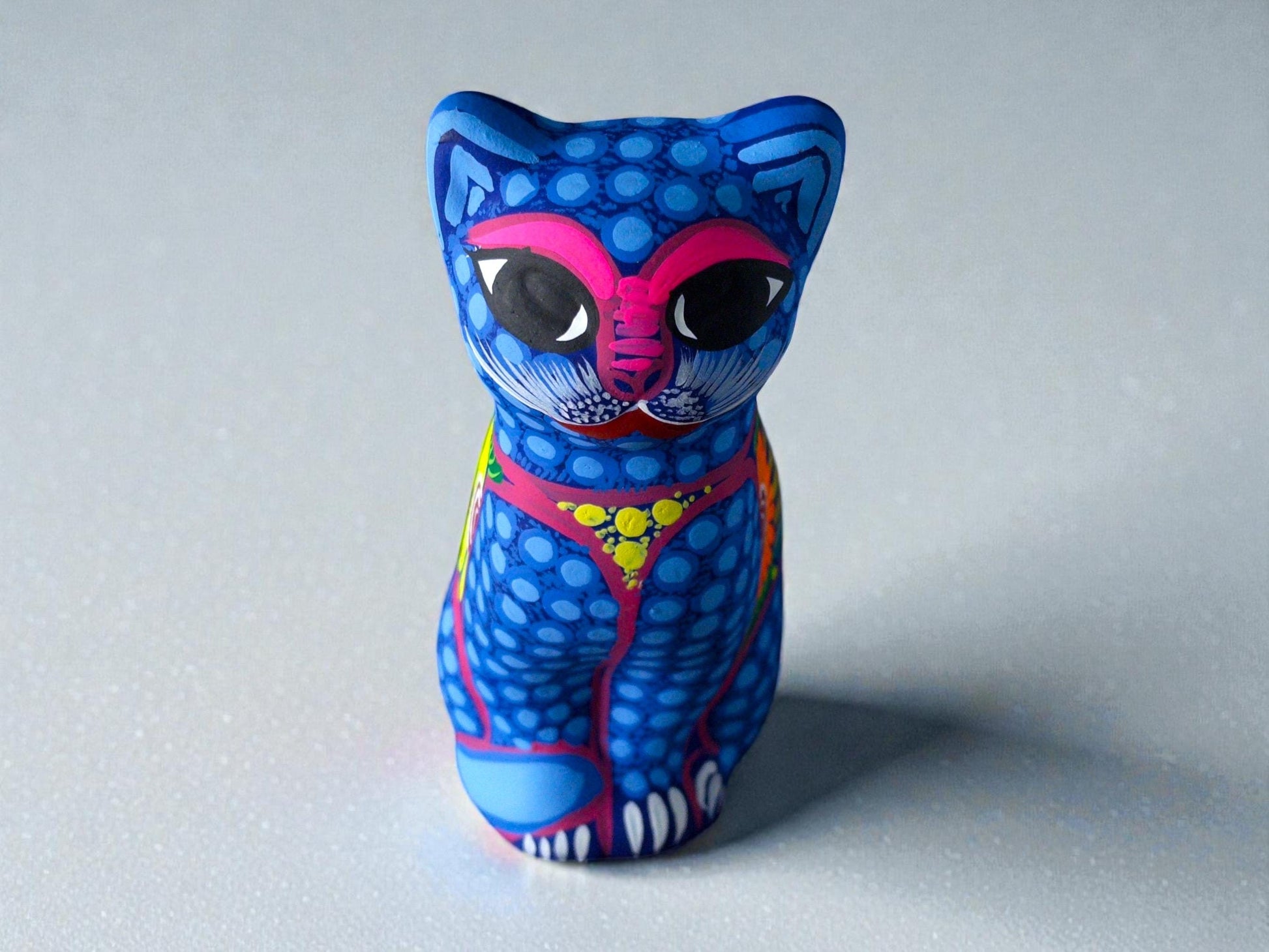 Blue hand-painted clay cat alebrije with pink face markings, Mexican folk art figurine from Guanajuato
