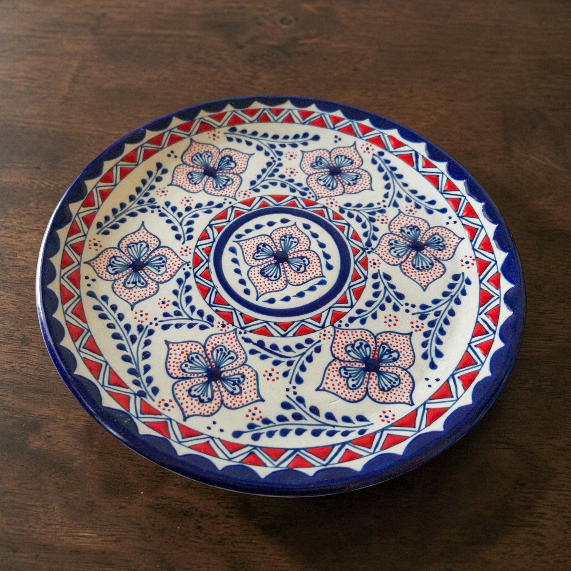 Blue and red stoneware dinner plate hand-painted detail
