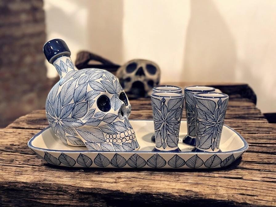 Blue stoneware skull decanter set with four shot glasses on a tray, handmade in Mexico for tequila and mezcal