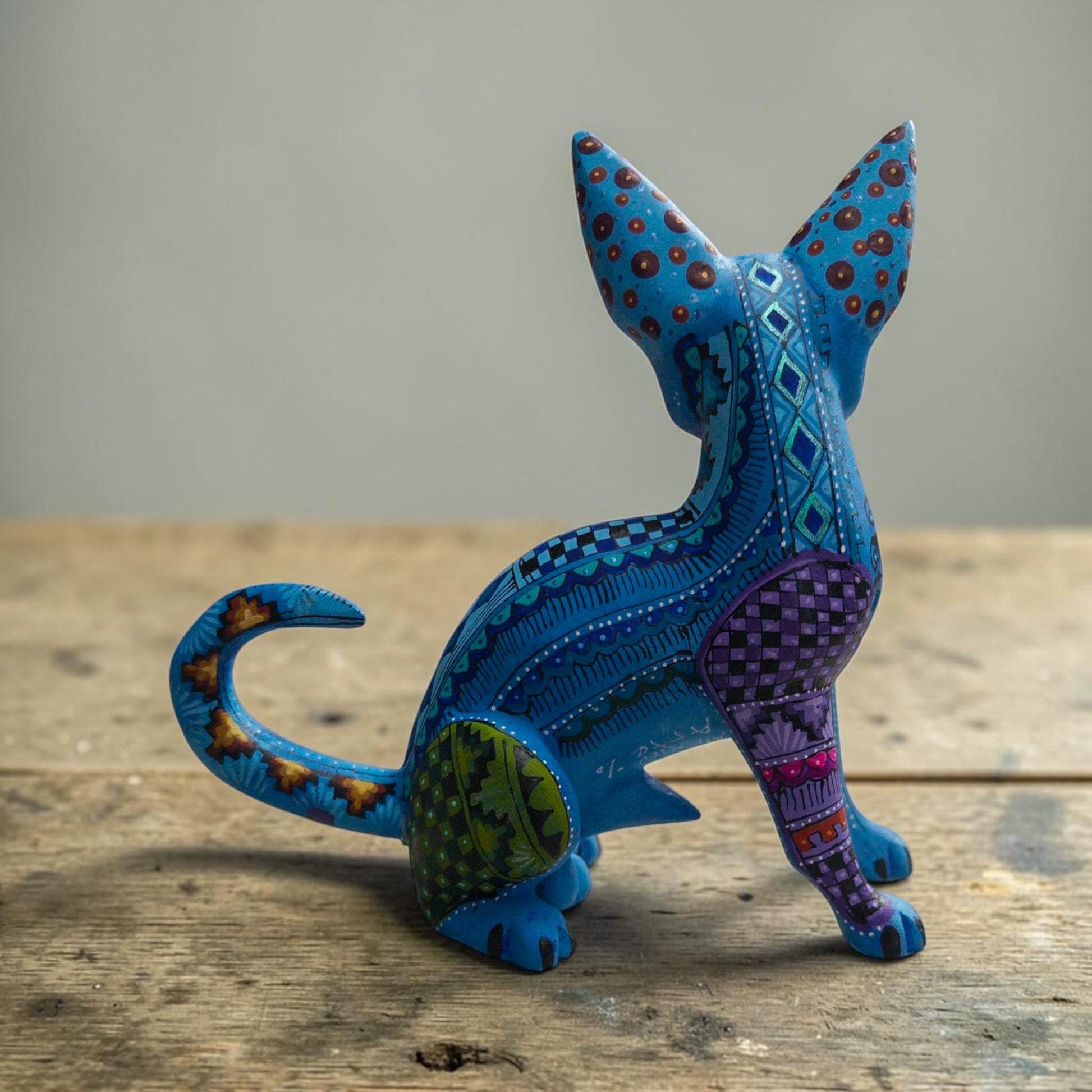 Wood dog alebrije held in hand showing its size