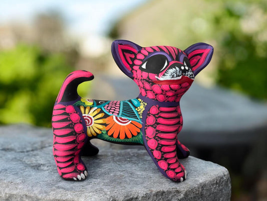 Pink dog alebrije clay sculpture with intricate hand-painted designs, Mexican folk art