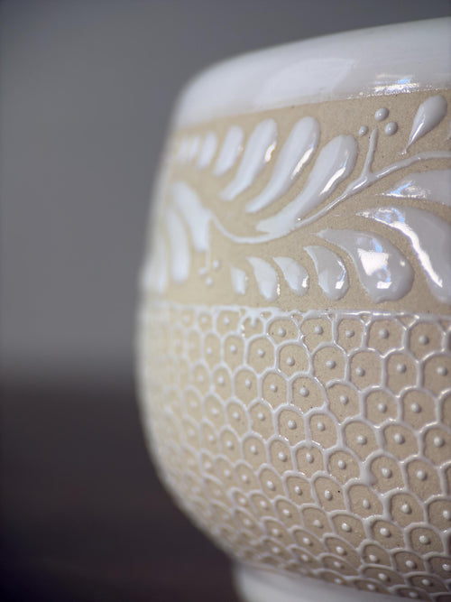Handmade stoneware mug with coffee, floral artisan design