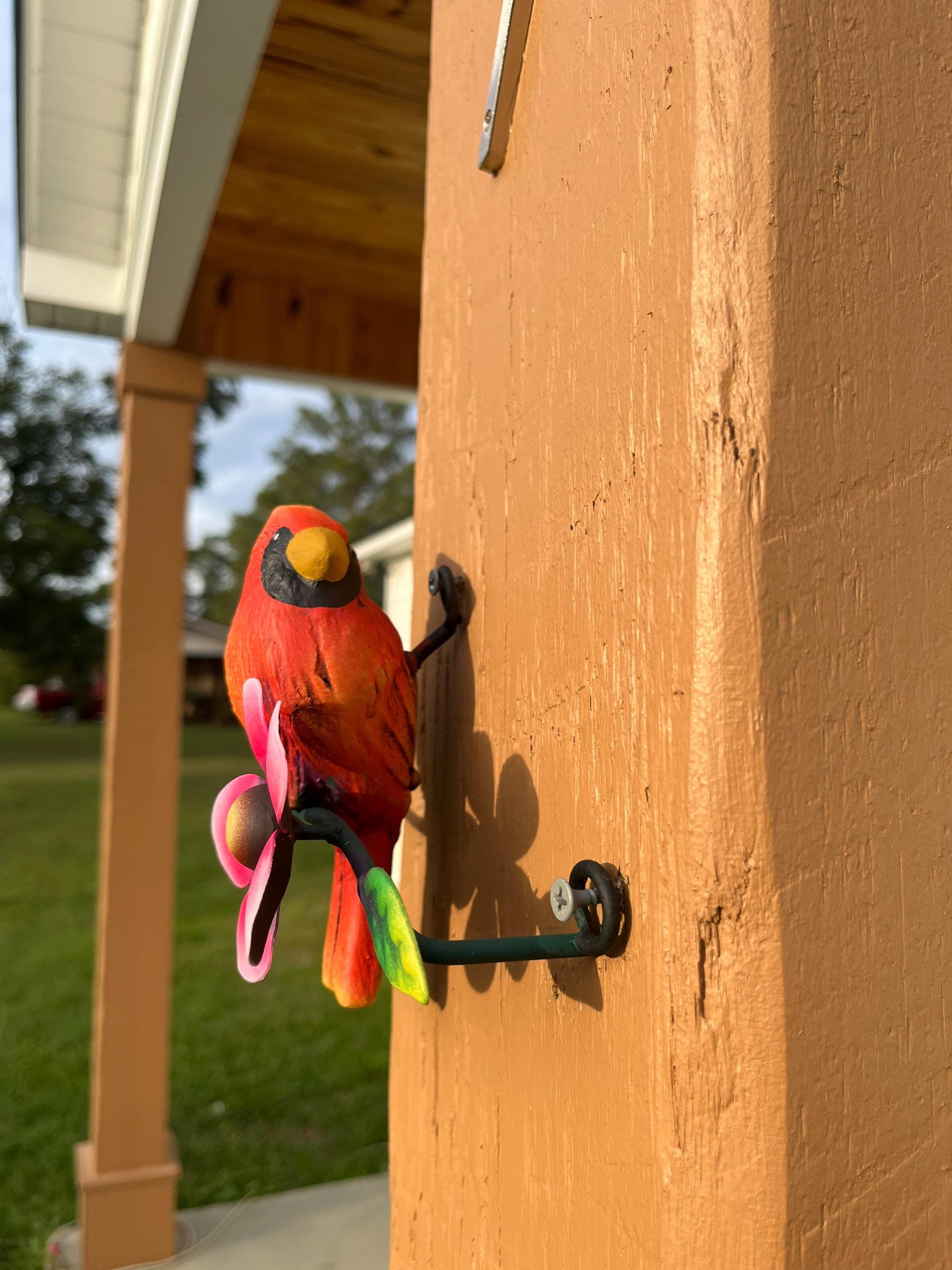 Red metal cardinal wall decor in garden, handmade Mexican wall art