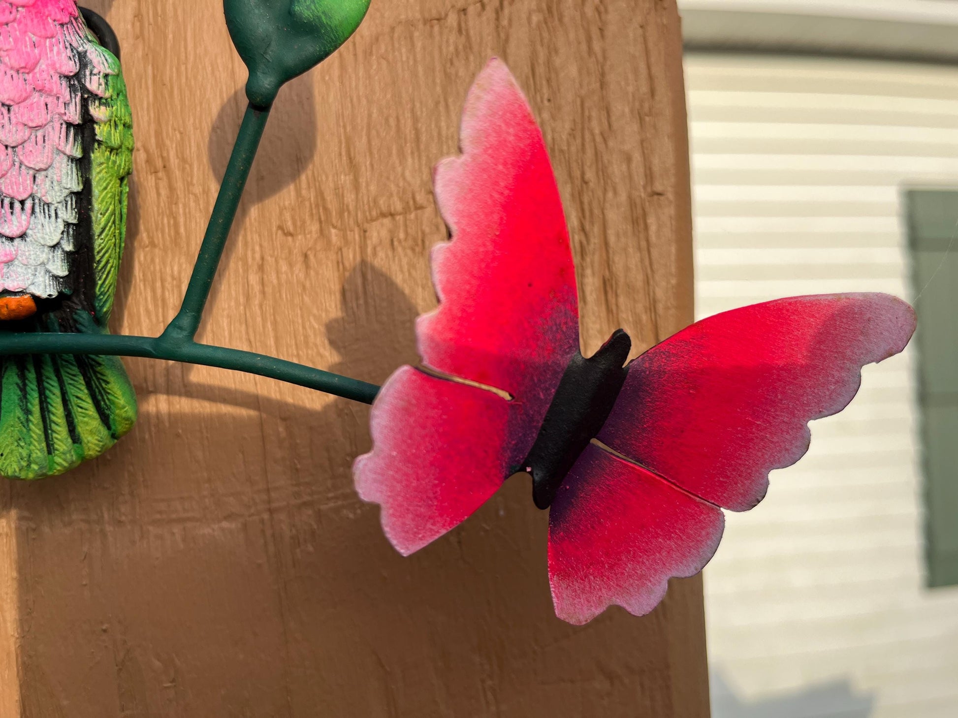 Pink butterfly detail on metal hummingbird wall art, handmade Mexican folk art