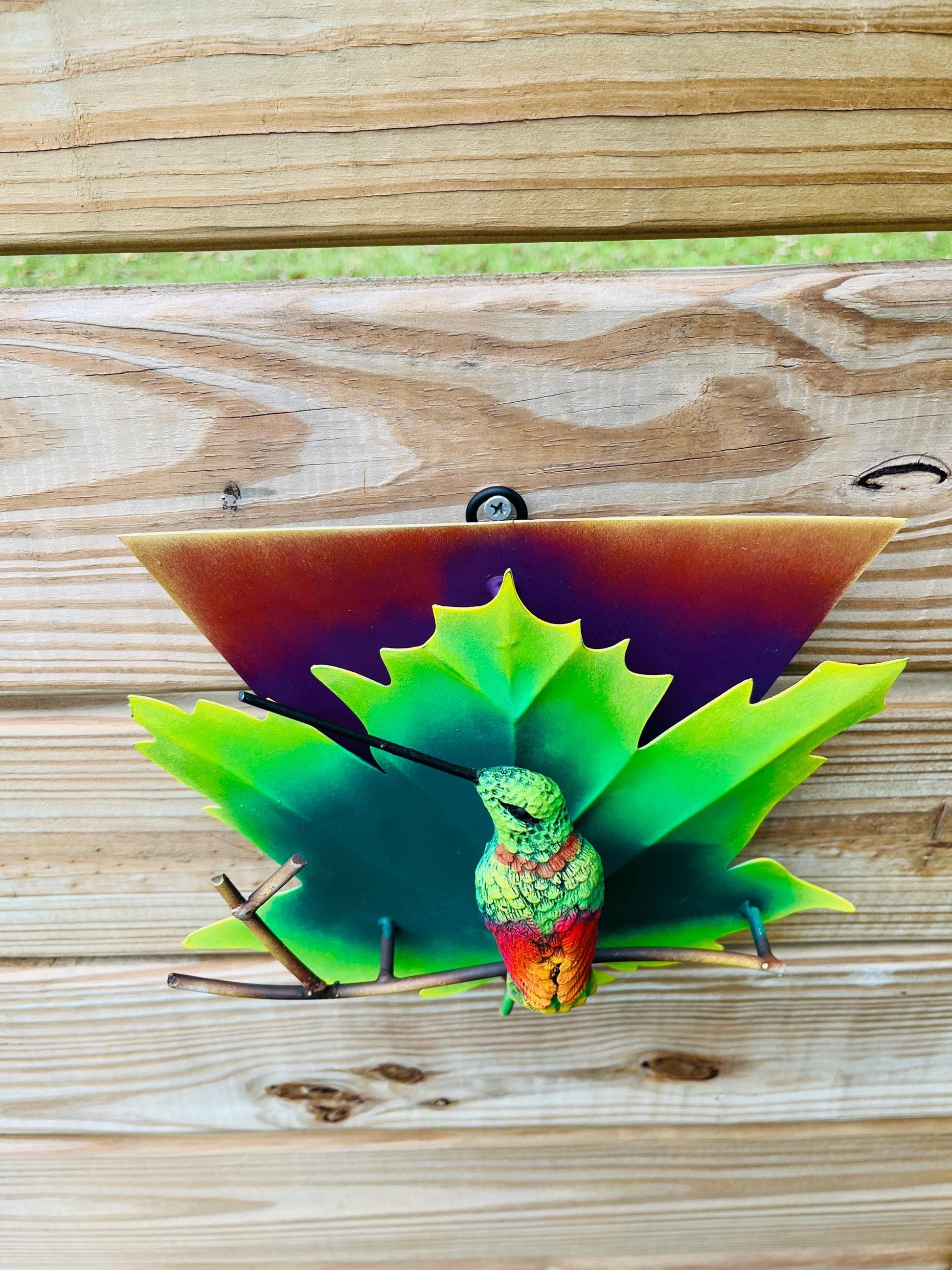 Green metal hummingbird wall art on patio, handmade Mexican outdoor decor