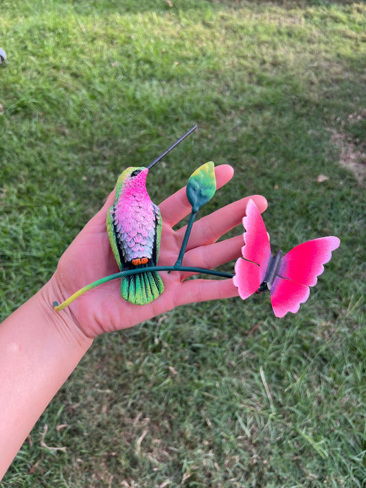 Green and pink metal hummingbird wall decor held in hand, handmade Mexican wall art