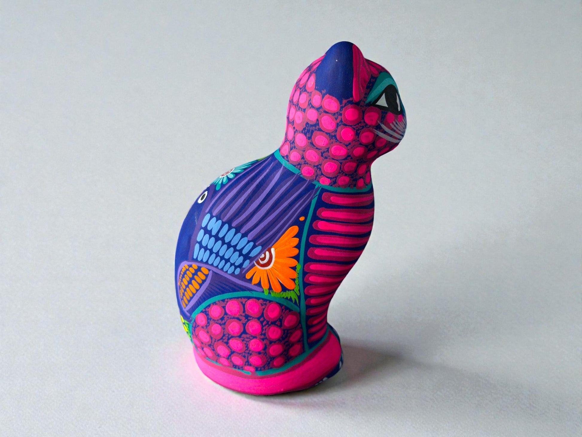 Pink hand-painted clay cat alebrije with bold patterns, Mexican folk art figurine from Guanajuato