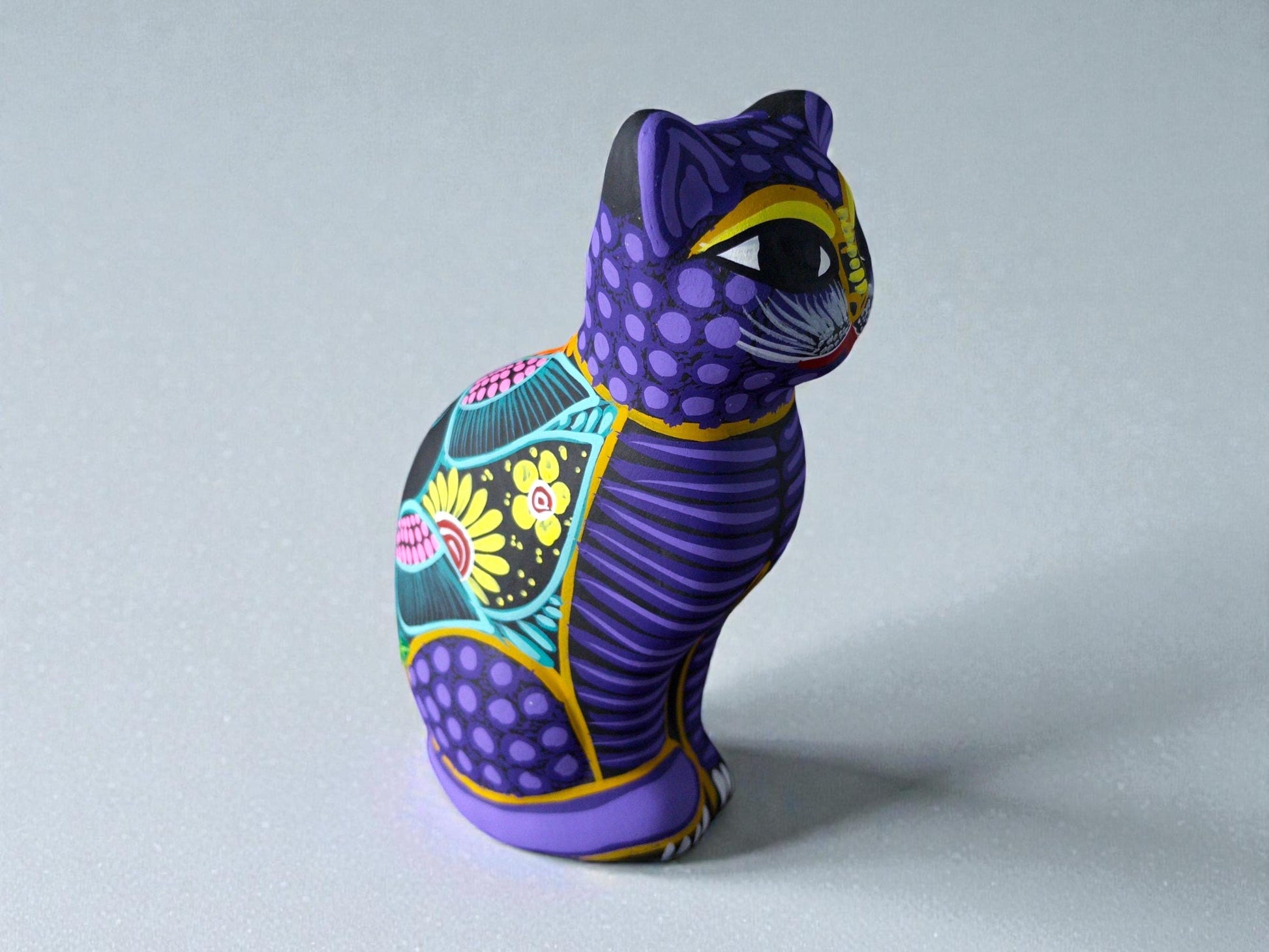 Purple hand-painted clay cat alebrije with floral patterns, Mexican folk art figurine from Guanajuato